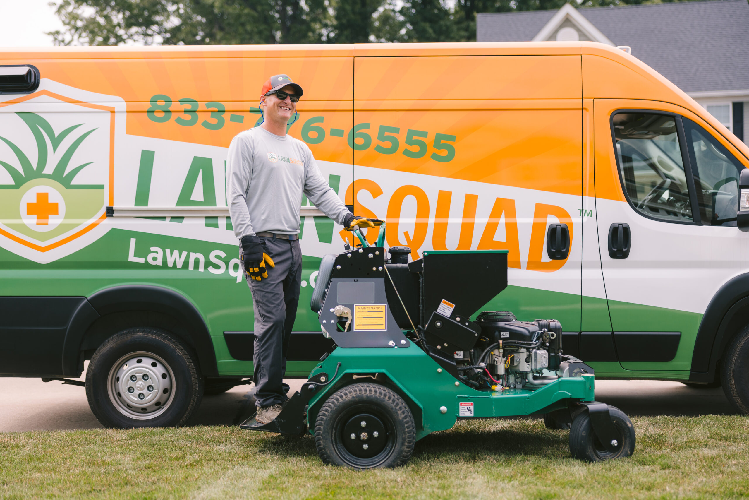 man on lawn equipment in front of van