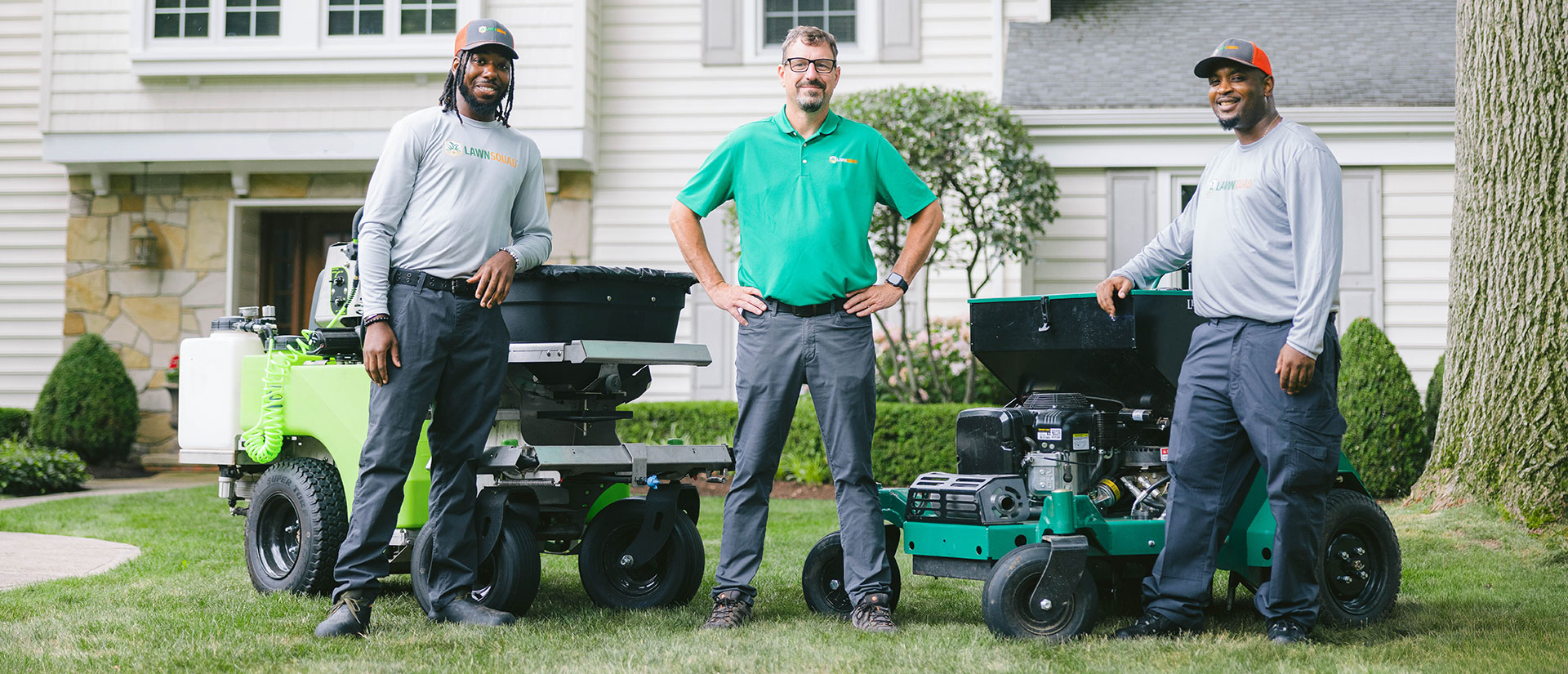 3 men standing on grass in front of a house