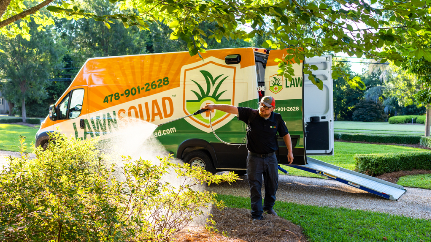 Man in front of lawn with Lawn Squad van